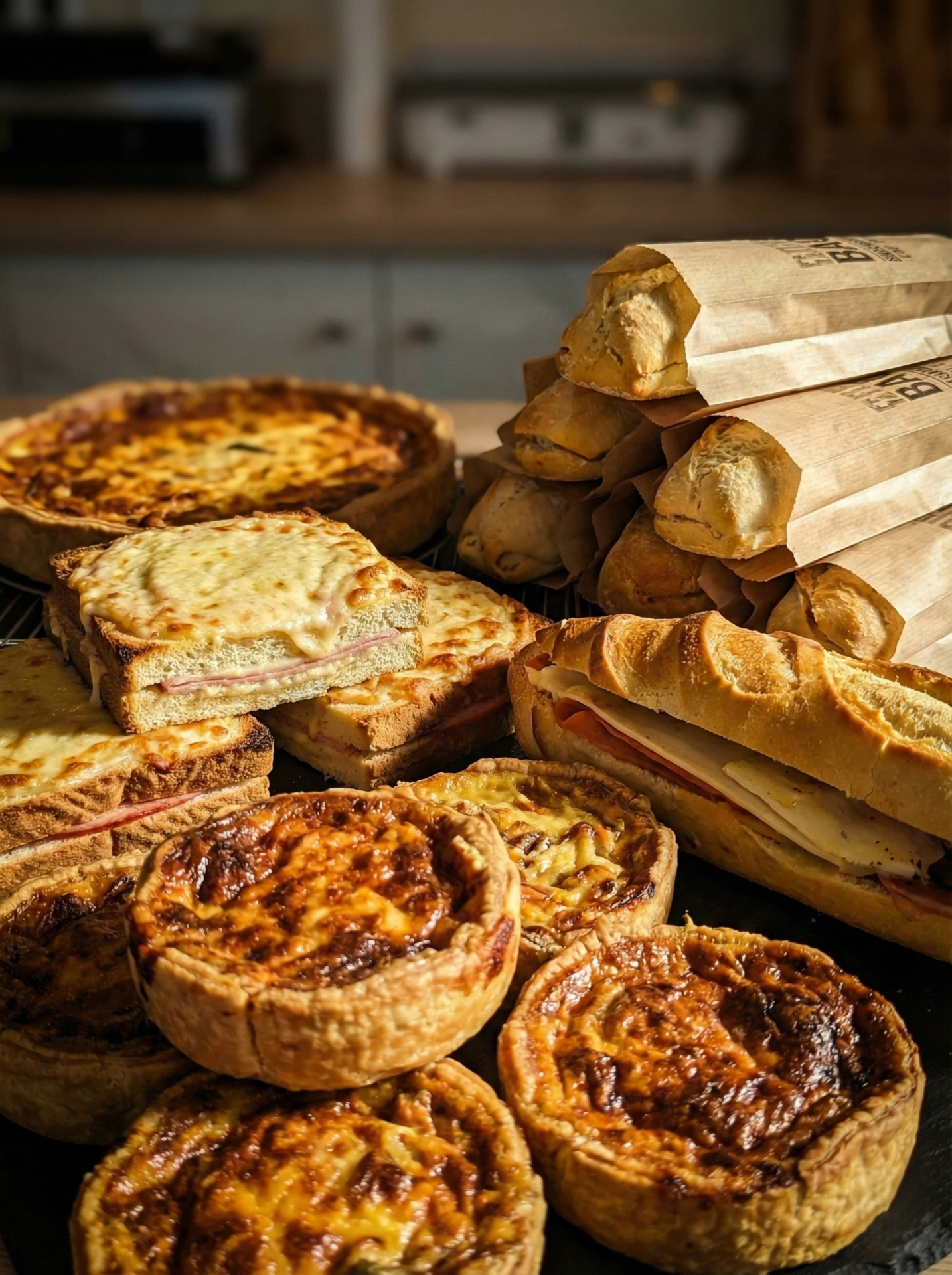 Assortiment de produits traiteur en boulangerie avec quiches, croque-monsieur et sandwichs.